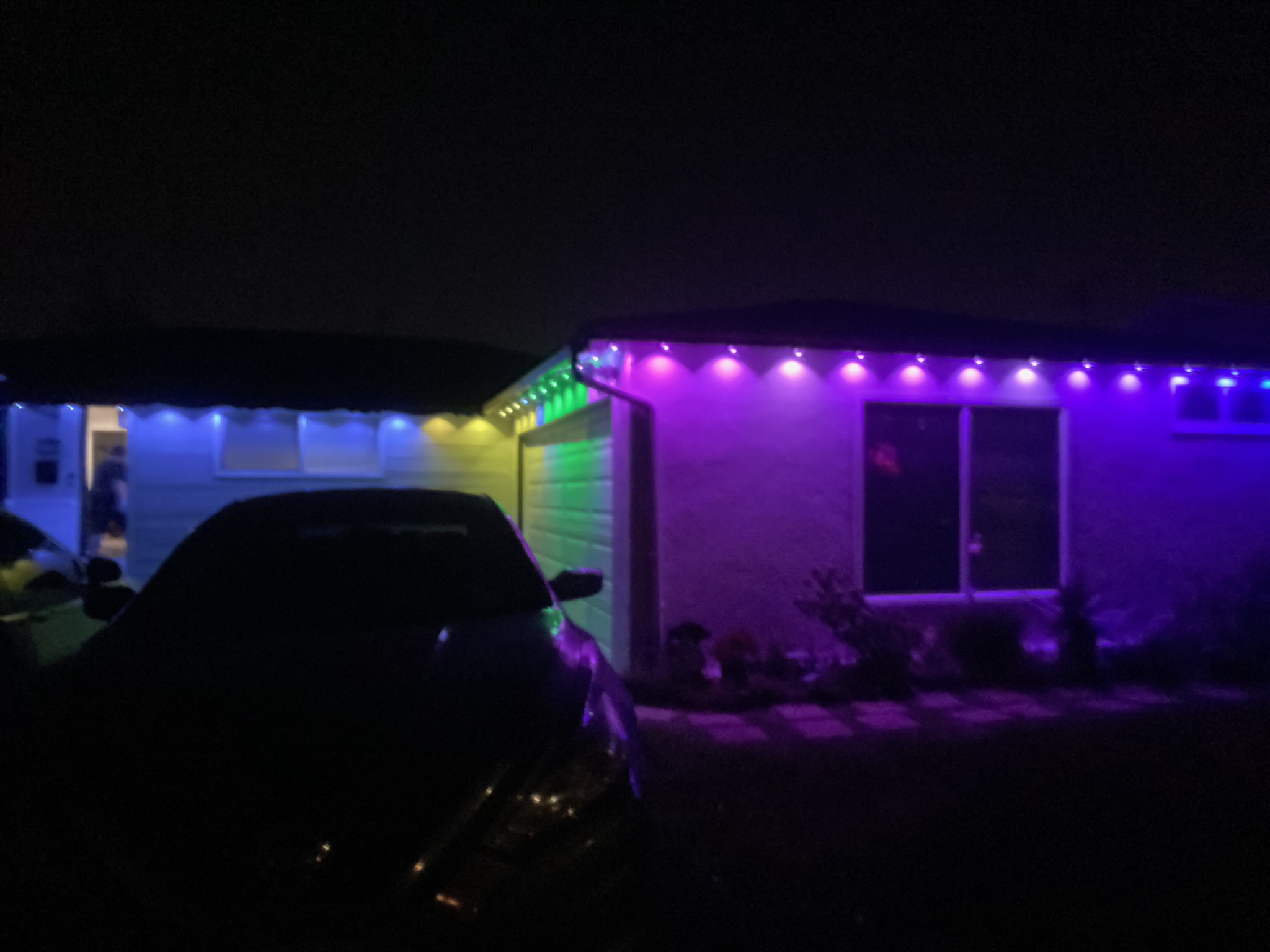Purple and green permanent outdoor lights on a home